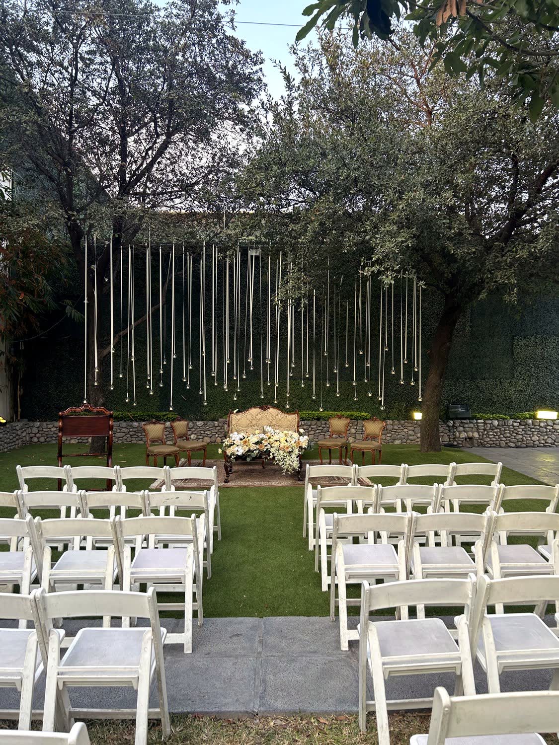 Rincón de ceremonias con cortinas de luces y sillas frente al altar